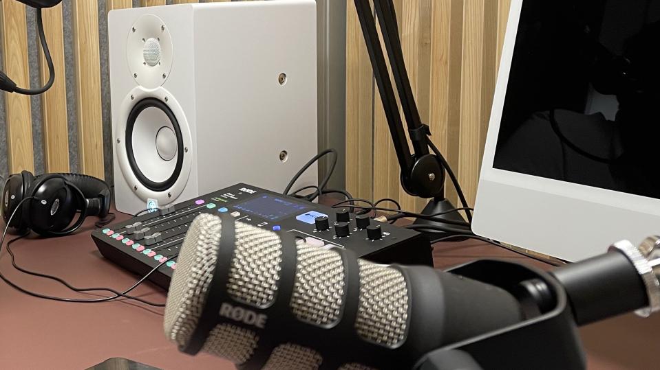 Illustrasjonsbilde av et podkaststudio. Mikrofonen i forkant, bak skimtes en lydmikser og en høyttaler.