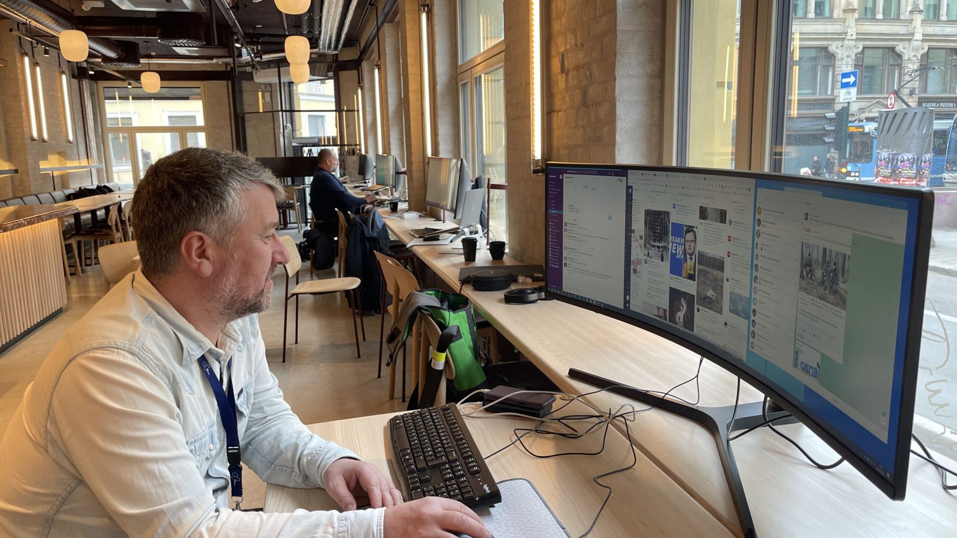 Sindre Ness fra NRK ser inn i en stor, buet skjerm. Bak ser vi at det sitter noen i bakgrunnen. 